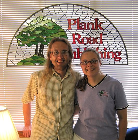 Tom and Lynn in front of our stained glass logo